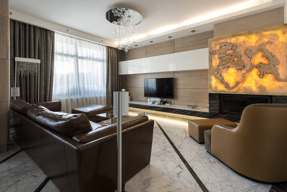 На фото: большая открытая гостиная комната в современном стиле с бежевыми стенами, мраморным полом, горизонтальным камином, фасадом камина из камня и телевизором на стене с