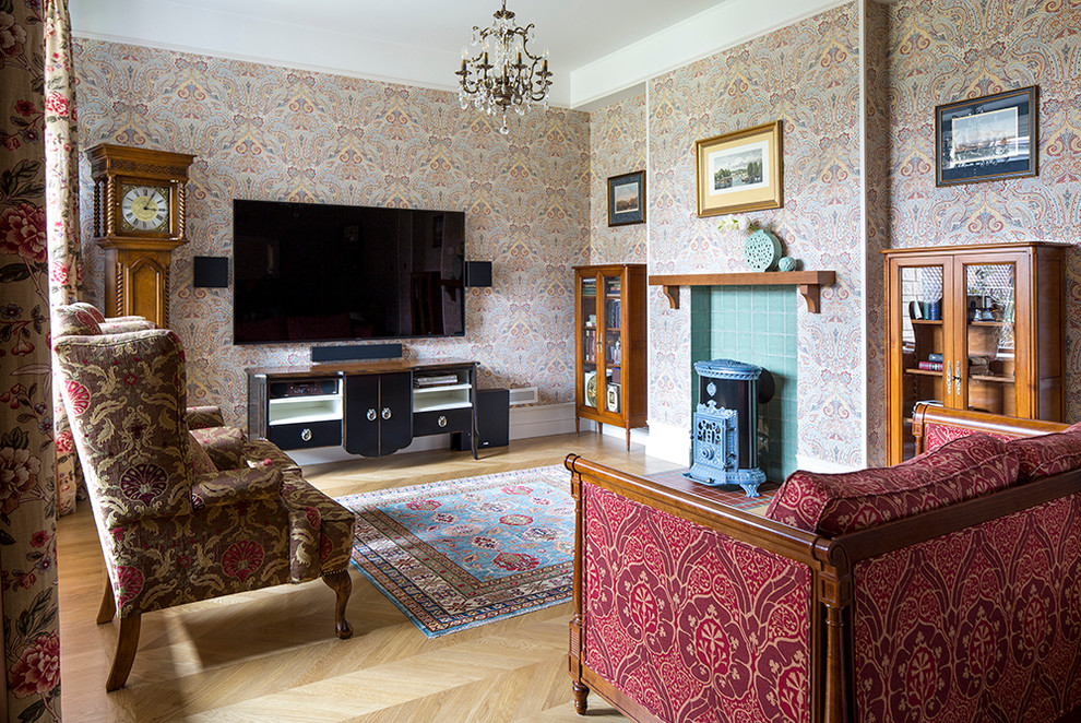 Aménagement d'un salon classique avec un mur marron, parquet clair, un poêle à bois et un téléviseur fixé au mur.