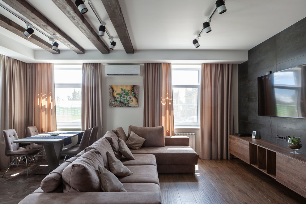 Large contemporary open plan living room in Moscow with white walls, medium hardwood flooring, a wall mounted tv and brown floors.