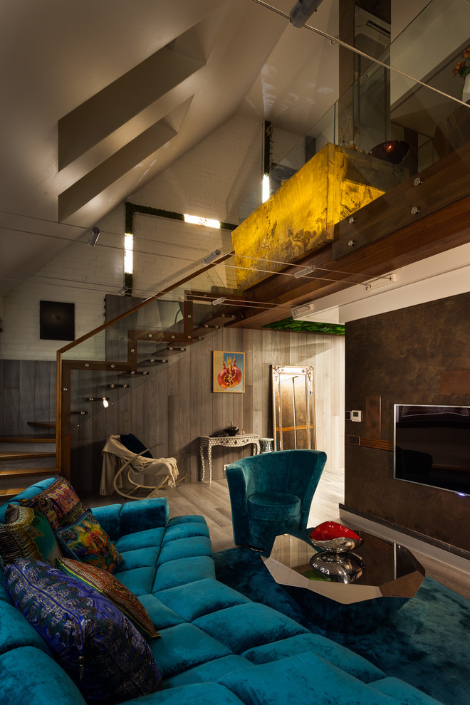 Идея дизайна: большая двухуровневая гостиная комната в стиле лофт с паркетным полом среднего тона, телевизором на стене, серым полом и разноцветными стенами