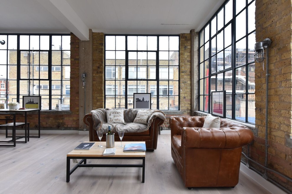 Mid-sized urban formal and open concept medium tone wood floor and beige floor living room photo in London with brown walls