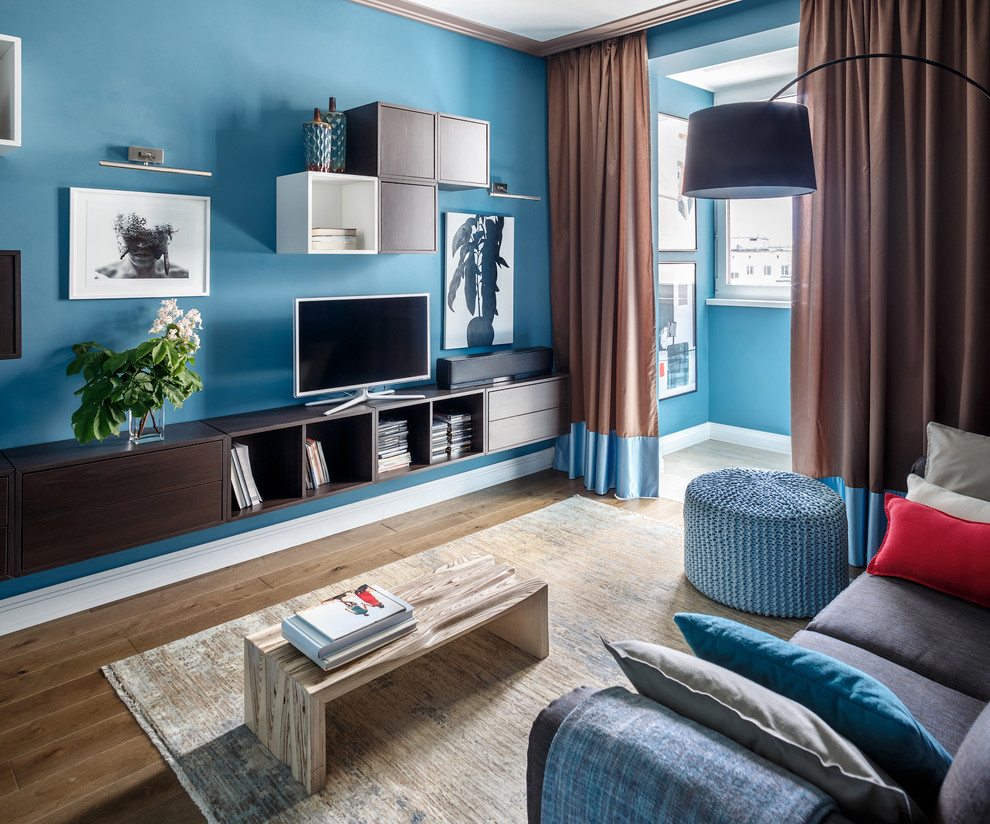 На фото: гостиная комната в современном стиле с синими стенами, паркетным полом среднего тона и коричневым полом