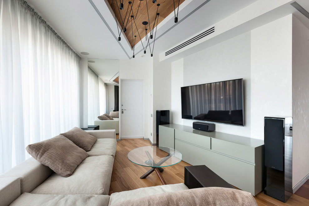 Immagine di un grande soggiorno design aperto con pareti bianche, pavimento in legno massello medio, TV a parete e pavimento marrone