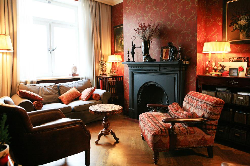 Cette photo montre un salon victorien de taille moyenne avec un mur rouge, un sol en bois brun, une cheminée standard, un manteau de cheminée en métal et un sol jaune.