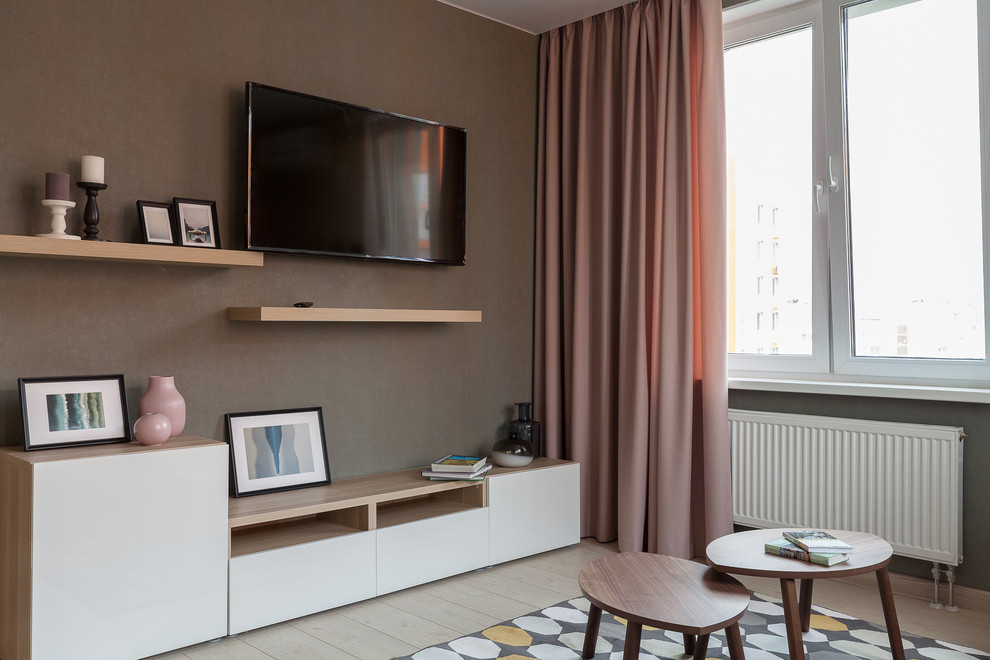 Modelo de salón cerrado actual de tamaño medio con suelo laminado, televisor colgado en la pared, suelo beige y paredes marrones