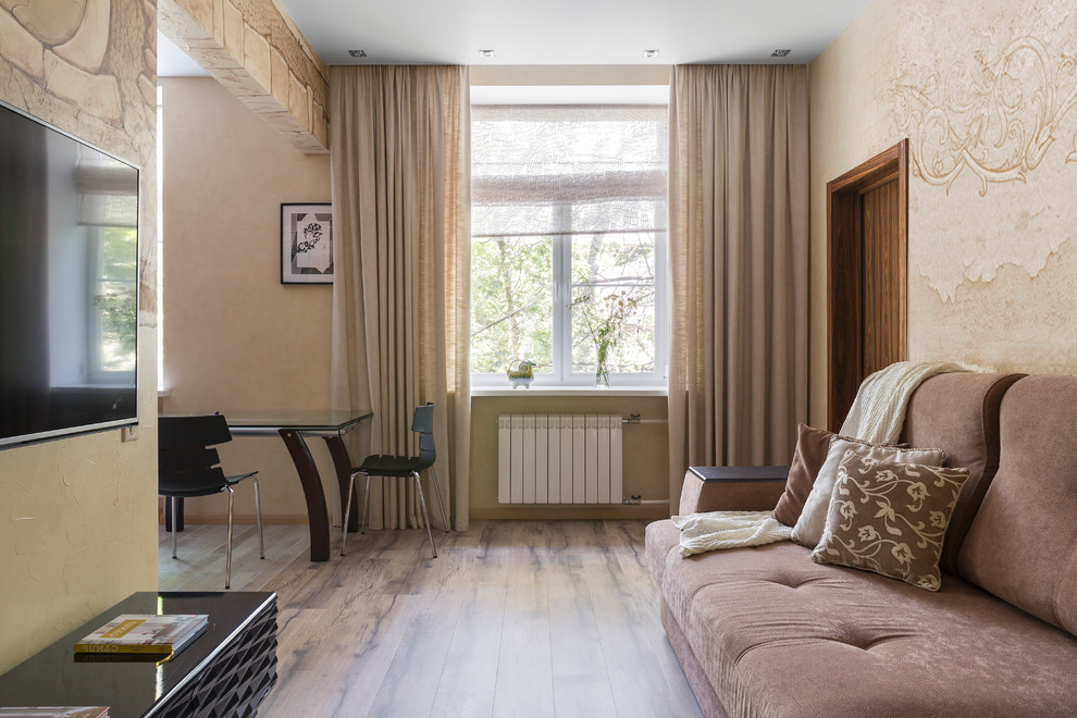 Immagine di un soggiorno contemporaneo di medie dimensioni e aperto con sala formale, pavimento in laminato, TV a parete e pavimento beige