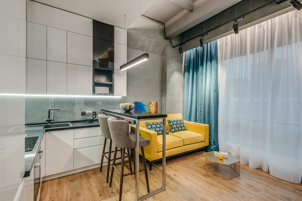 Small urban open plan living room in Moscow with grey walls, medium hardwood flooring and brown floors.