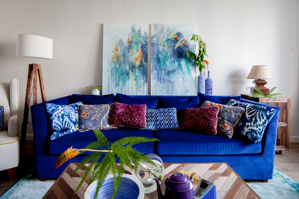 Идея дизайна: гостиная комната в стиле неоклассика (современная классика) с серыми стенами, светлым паркетным полом и синим диваном