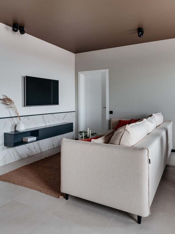Imagen de salón contemporáneo pequeño con suelo de baldosas de porcelana, televisor colgado en la pared y suelo gris