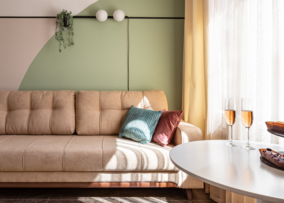 На фото: открытая гостиная комната среднего размера в скандинавском стиле с с книжными шкафами и полками, зелеными стенами, полом из керамогранита и коричневым полом с