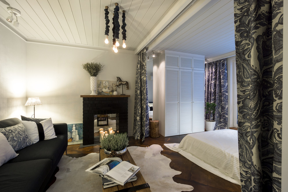 На фото: открытая гостиная комната среднего размера в стиле неоклассика (современная классика) с стандартным камином, фасадом камина из кирпича и белыми стенами