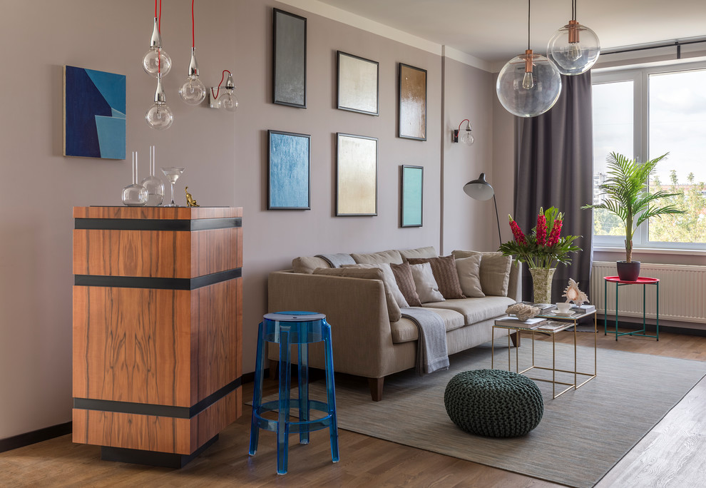 Modelo de salón con barra de bar contemporáneo con suelo de madera en tonos medios y paredes grises