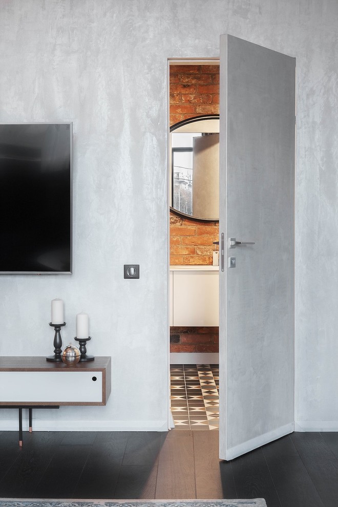 Diseño de salón contemporáneo de tamaño medio con paredes grises, suelo de baldosas de cerámica, televisor colgado en la pared y suelo marrón