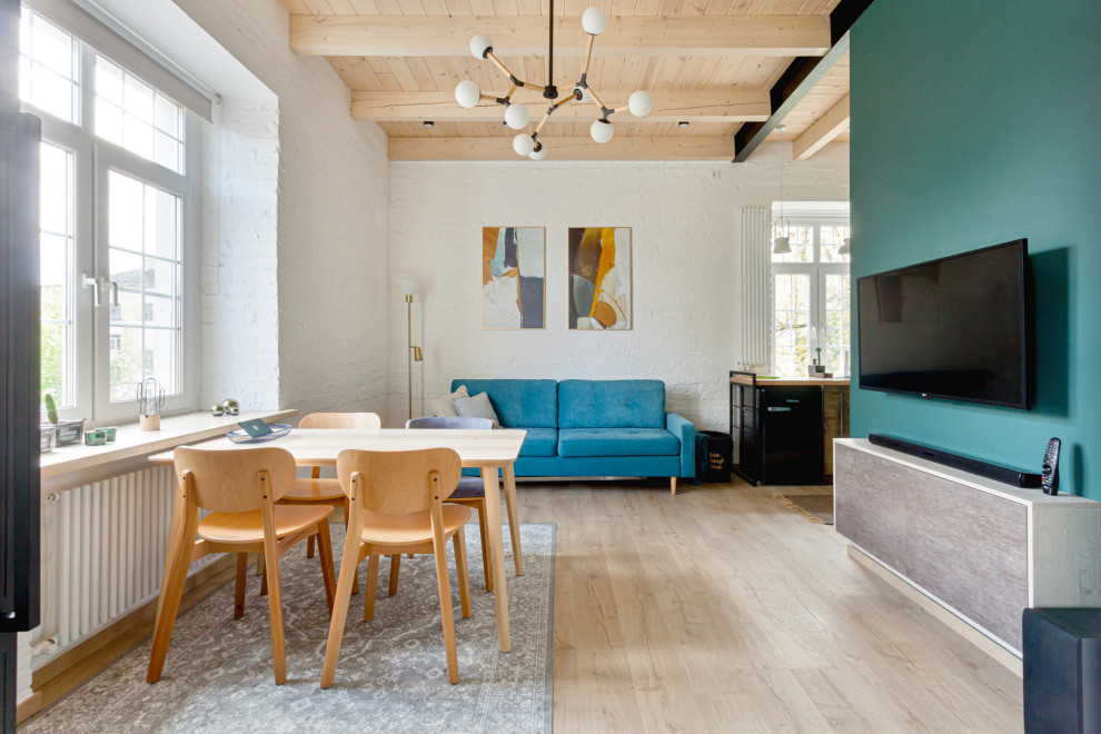 Esempio di un soggiorno industriale aperto con pareti blu, parquet chiaro, TV a parete, pavimento beige, travi a vista, soffitto in legno e pareti in mattoni