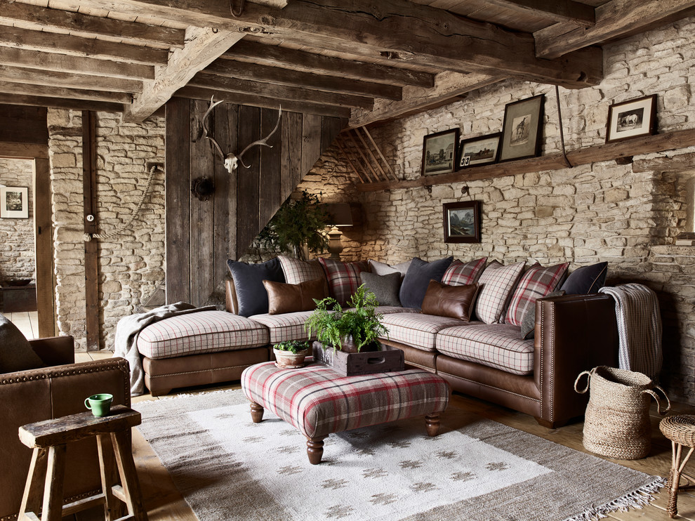 Modelo de salón rural con paredes marrones, suelo de madera en tonos medios, suelo marrón y piedra