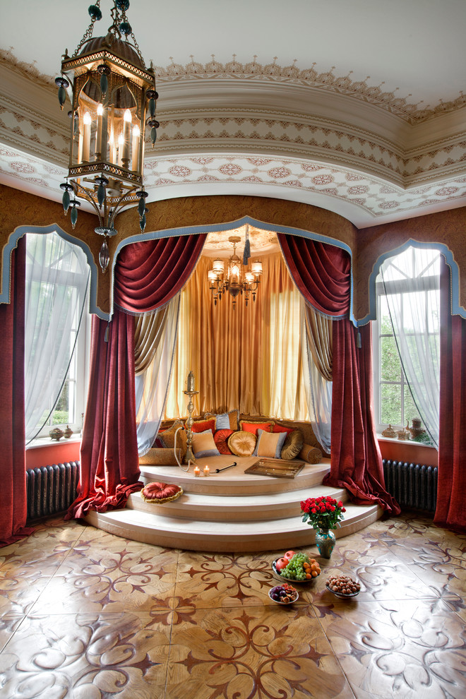 На фото: гостиная комната в средиземноморском стиле с красными стенами и темным паркетным полом без камина, телевизора с