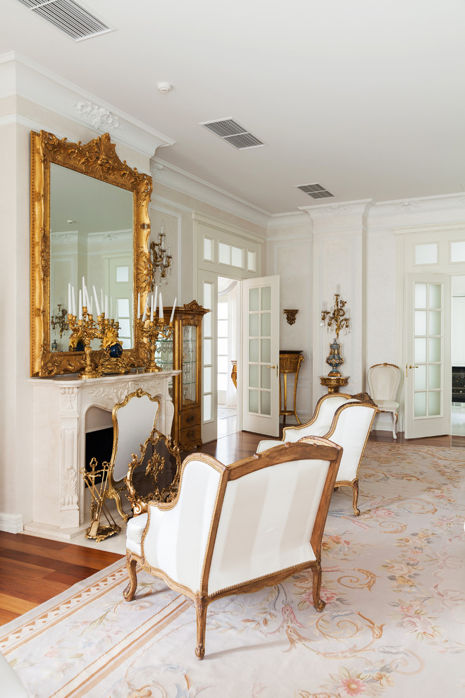 На фото: парадная гостиная комната в классическом стиле с белыми стенами, ковровым покрытием и стандартным камином с