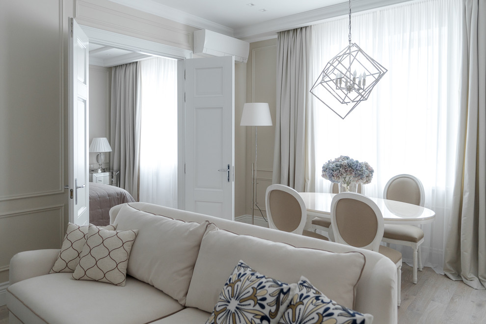 Esempio di un soggiorno chic aperto con pareti beige, parquet chiaro e pavimento beige