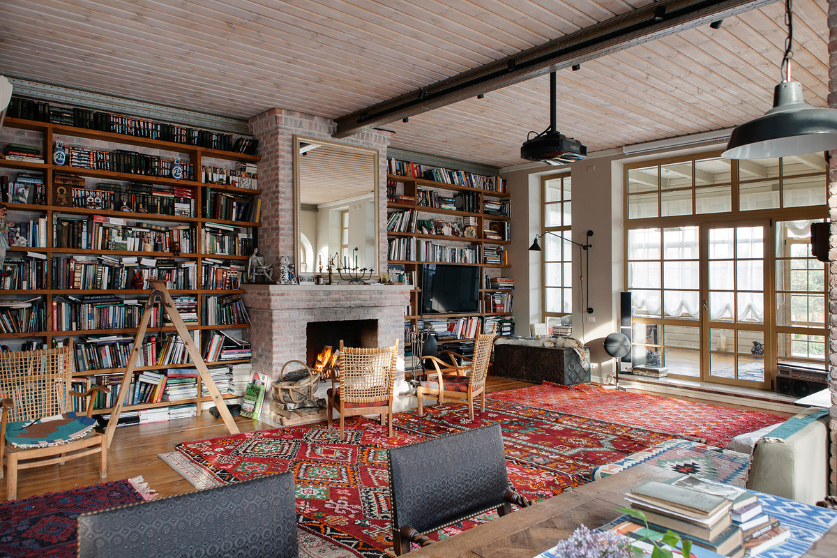 Cette image montre un salon design avec une bibliothèque ou un coin lecture, une cheminée standard, un manteau de cheminée en brique et un téléviseur indépendant.