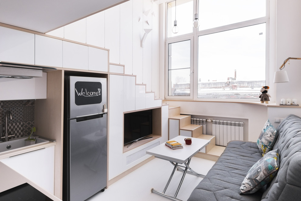 Foto de salón para visitas abierto nórdico pequeño con paredes blancas, suelo de madera clara, televisor independiente y suelo blanco