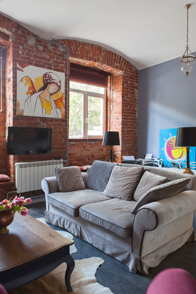 Стильный дизайн: открытая гостиная комната в стиле лофт с разноцветными стенами, темным паркетным полом и телевизором на стене - последний тренд
