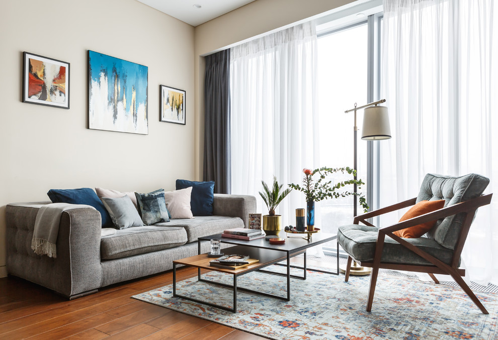 This is an example of a contemporary formal open plan living room in Moscow with beige walls, medium hardwood flooring and brown floors.