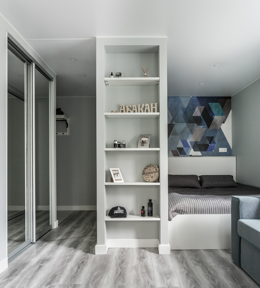 Diseño de salón para visitas abierto actual con paredes grises, suelo de madera clara y suelo gris