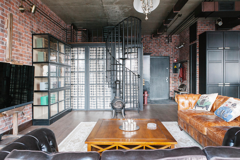 Foto de salón tipo loft industrial con paredes marrones, suelo de madera en tonos medios, estufa de leña, televisor colgado en la pared y suelo marrón