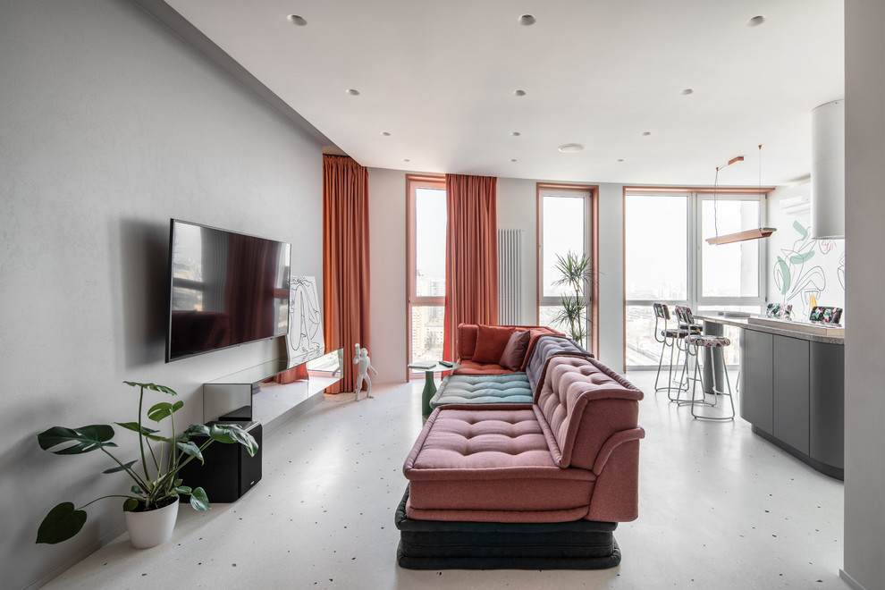На фото: открытая гостиная комната в современном стиле с серыми стенами, телевизором на стене и серым полом с