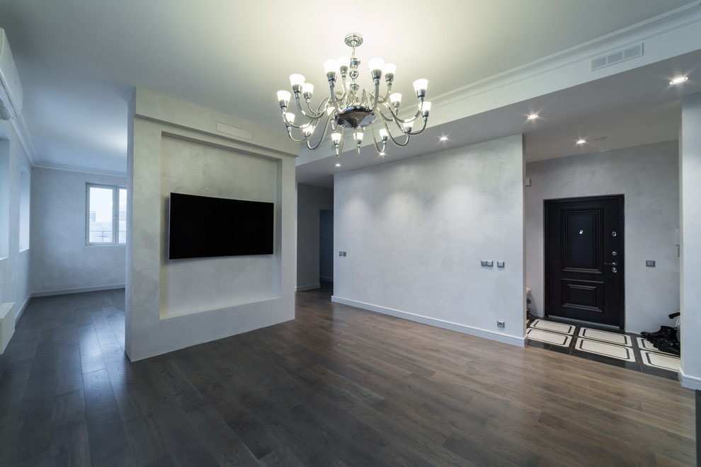 Diseño de salón para visitas cerrado contemporáneo grande sin chimenea con paredes grises, suelo de madera oscura, televisor colgado en la pared y suelo marrón