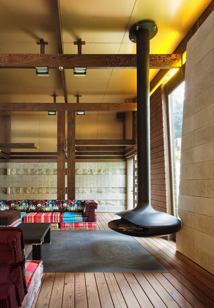 Idee per un soggiorno minimal con pareti beige, pavimento in legno massello medio e camino sospeso