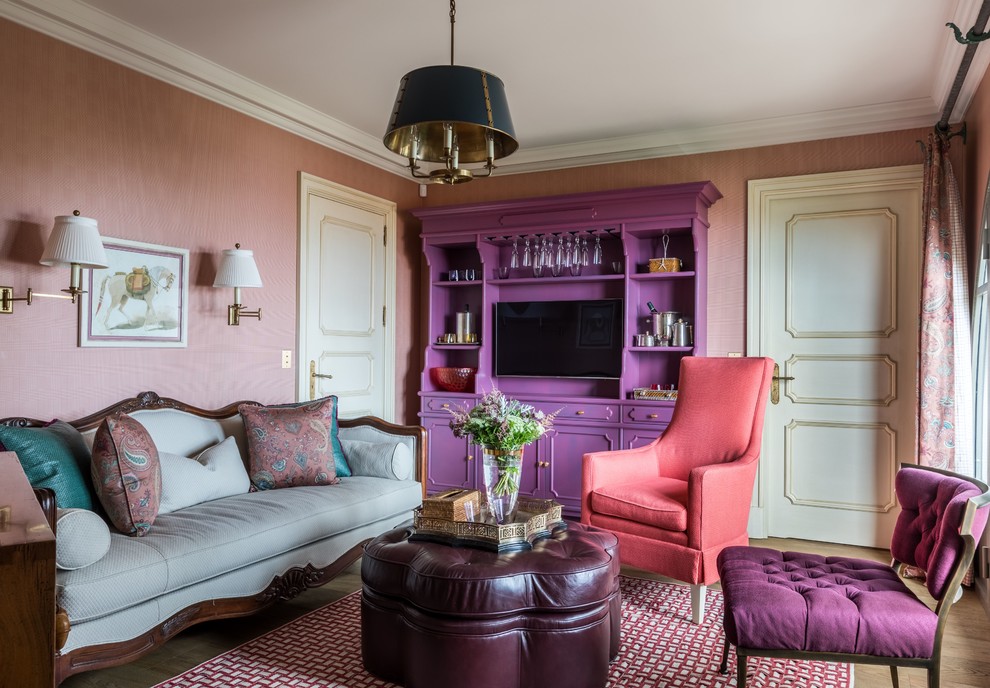 Inredning av ett klassiskt vardagsrum, med rosa väggar, mörkt trägolv, en inbyggd mediavägg och brunt golv