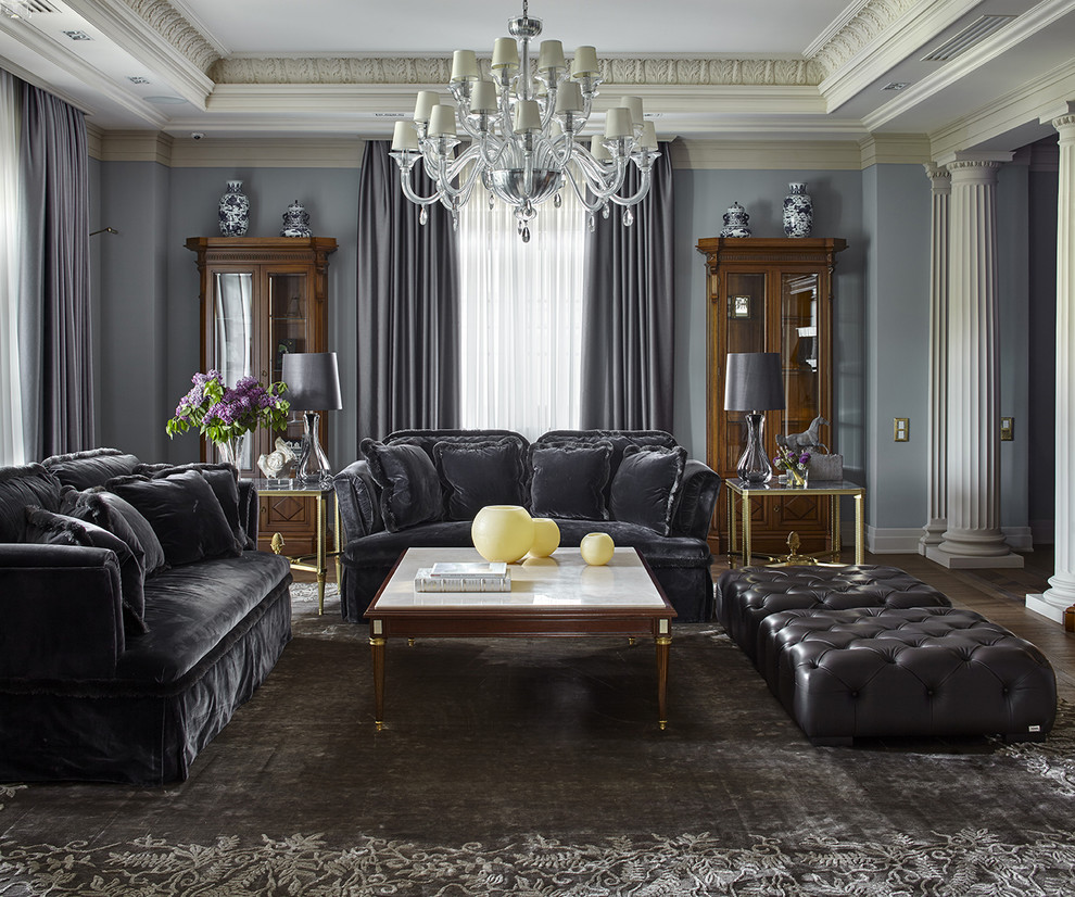 Aménagement d'un salon classique fermé avec une salle de réception, un mur bleu, parquet foncé, un sol marron et canapé noir.