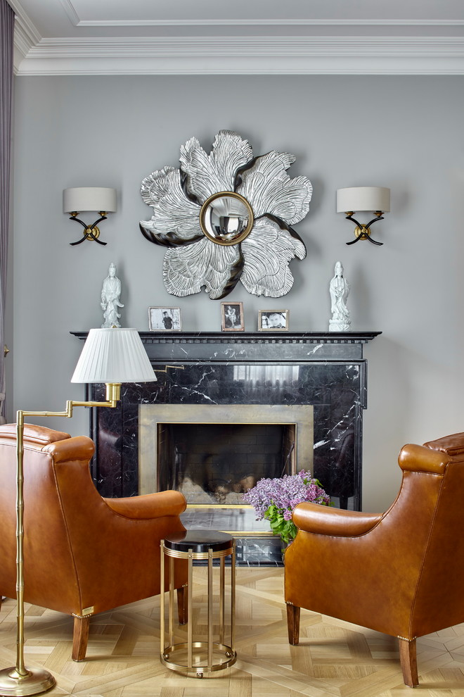Inspiration pour un salon traditionnel avec un mur gris, parquet clair, une cheminée standard, un manteau de cheminée en pierre et un sol beige.