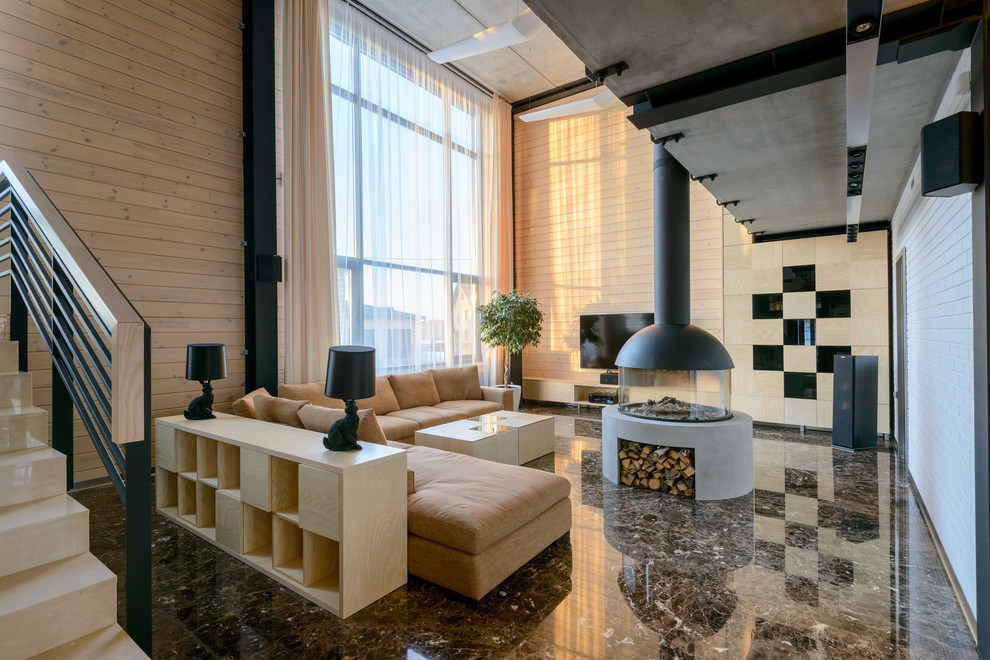 Источник вдохновения для домашнего уюта: двухуровневая гостиная комната в современном стиле с бежевыми стенами, двусторонним камином, фасадом камина из бетона и телевизором на стене