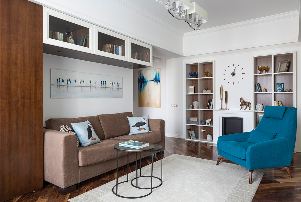 Idée de décoration pour un petit salon tradition fermé avec une bibliothèque ou un coin lecture, un mur blanc, parquet foncé et un sol marron.