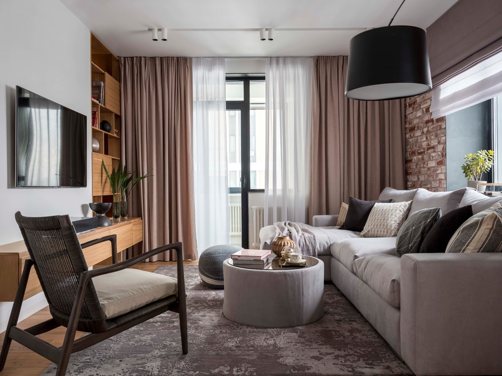 Esempio di un soggiorno contemporaneo aperto con sala formale, pareti bianche, pavimento in legno massello medio, TV a parete e pavimento marrone