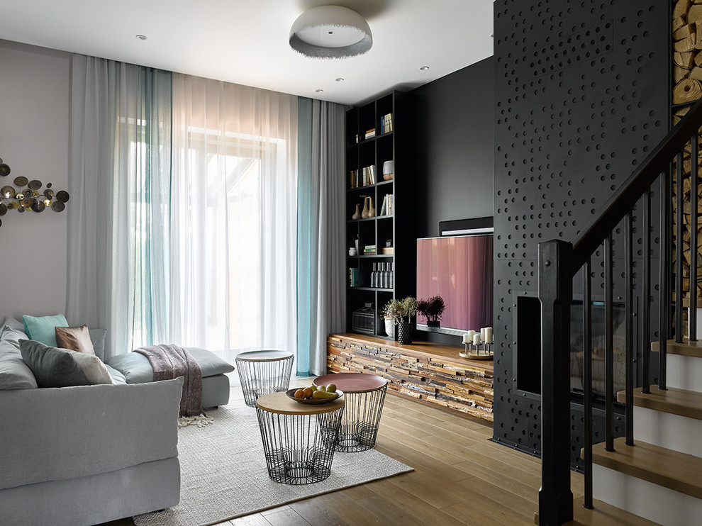 Idées déco pour un salon contemporain de taille moyenne et ouvert avec un mur noir, une cheminée standard, un manteau de cheminée en métal, un téléviseur fixé au mur, un sol beige et un sol en bois brun.
