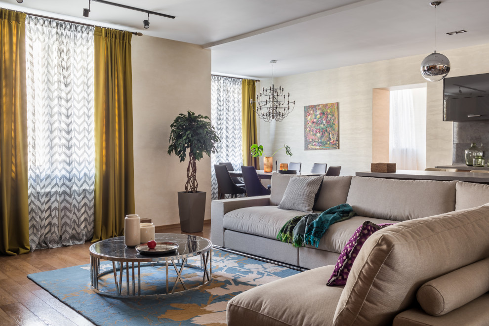 Стильный дизайн: открытая гостиная комната в современном стиле с бежевыми стенами, паркетным полом среднего тона и коричневым полом - последний тренд