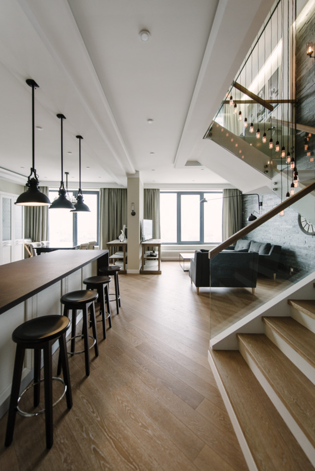 Inspiration for a large industrial open concept light wood floor and beige floor living room remodel in Moscow with a bar, beige walls and a wall-mounted tv