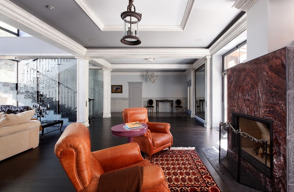 Idée de décoration pour un salon design avec parquet foncé, une cheminée standard, un manteau de cheminée en pierre et un sol marron.