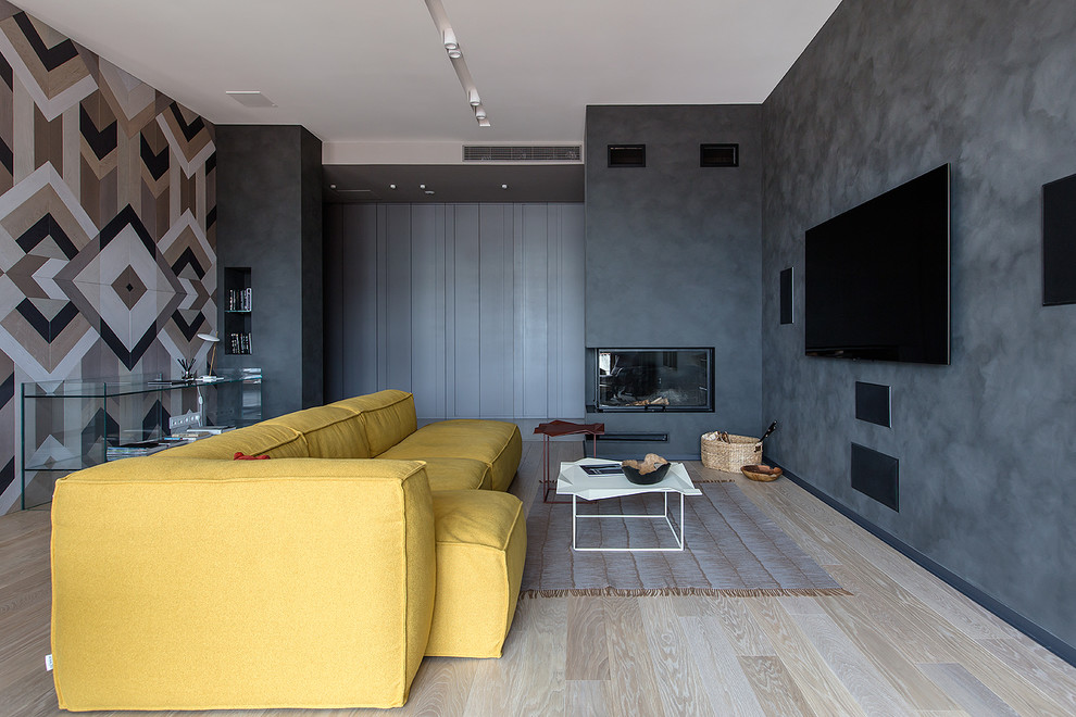 Réalisation d'un salon design ouvert avec une salle de réception, un mur gris, parquet clair, une cheminée d'angle, un manteau de cheminée en plâtre, un téléviseur fixé au mur et un sol beige.
