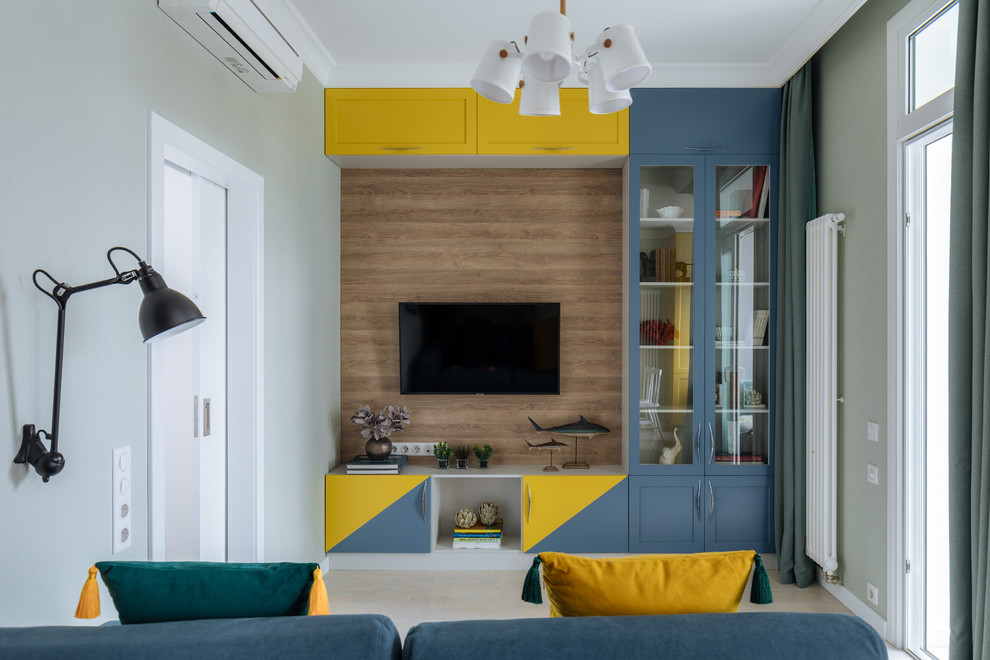 Свежая идея для дизайна: гостиная комната в стиле неоклассика (современная классика) с зелеными стенами, телевизором на стене, бежевым полом и синим диваном - отличное фото интерьера