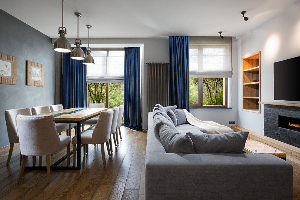 Mittelgroßes Modernes Wohnzimmer mit grauer Wandfarbe, Gaskamin, Kaminumrandung aus Stein und TV-Wand in Sonstige