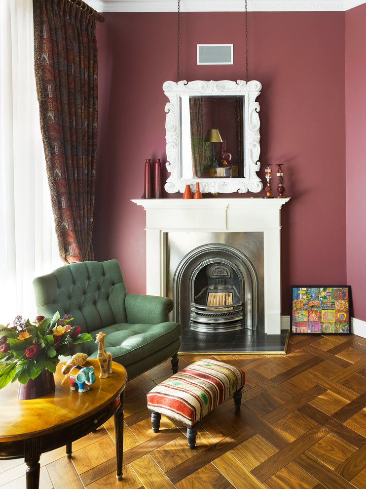 Idee per un soggiorno tradizionale con pavimento in legno massello medio, camino classico e pareti rosa