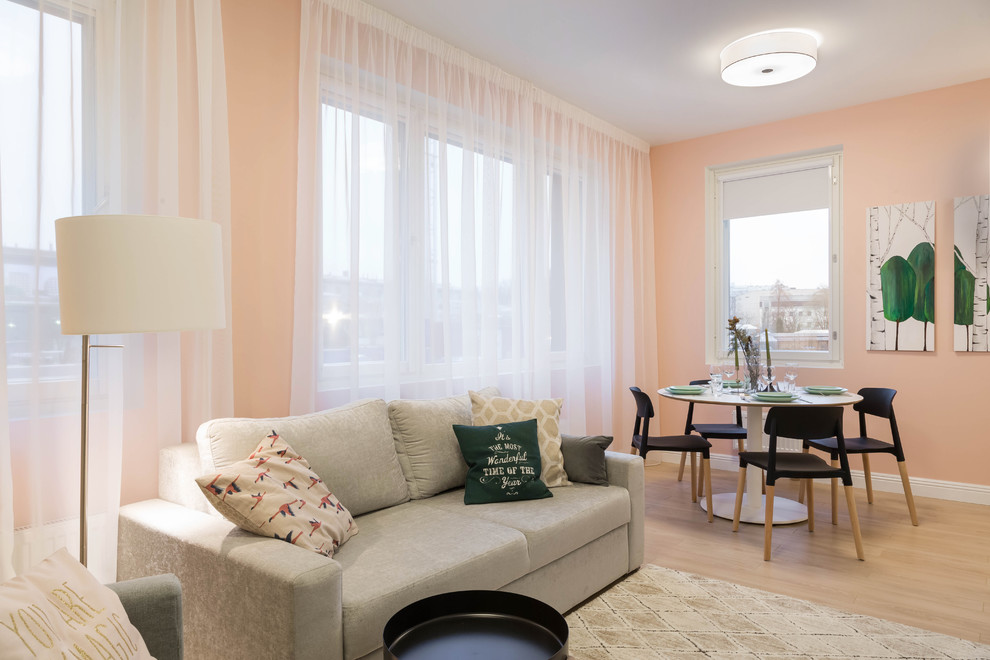 Esempio di un soggiorno di medie dimensioni e aperto con pareti rosa, pavimento in legno massello medio, nessun camino e TV autoportante