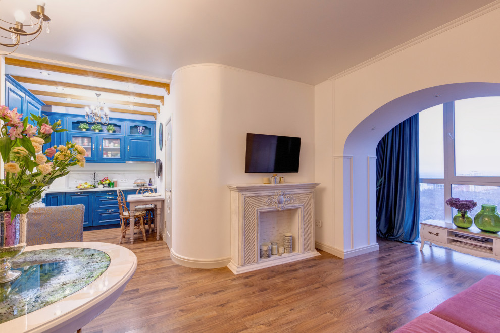 Cette photo montre un salon chic de taille moyenne et ouvert avec un mur beige, sol en stratifié, une cheminée ribbon, un manteau de cheminée en plâtre, un téléviseur fixé au mur et un sol beige.