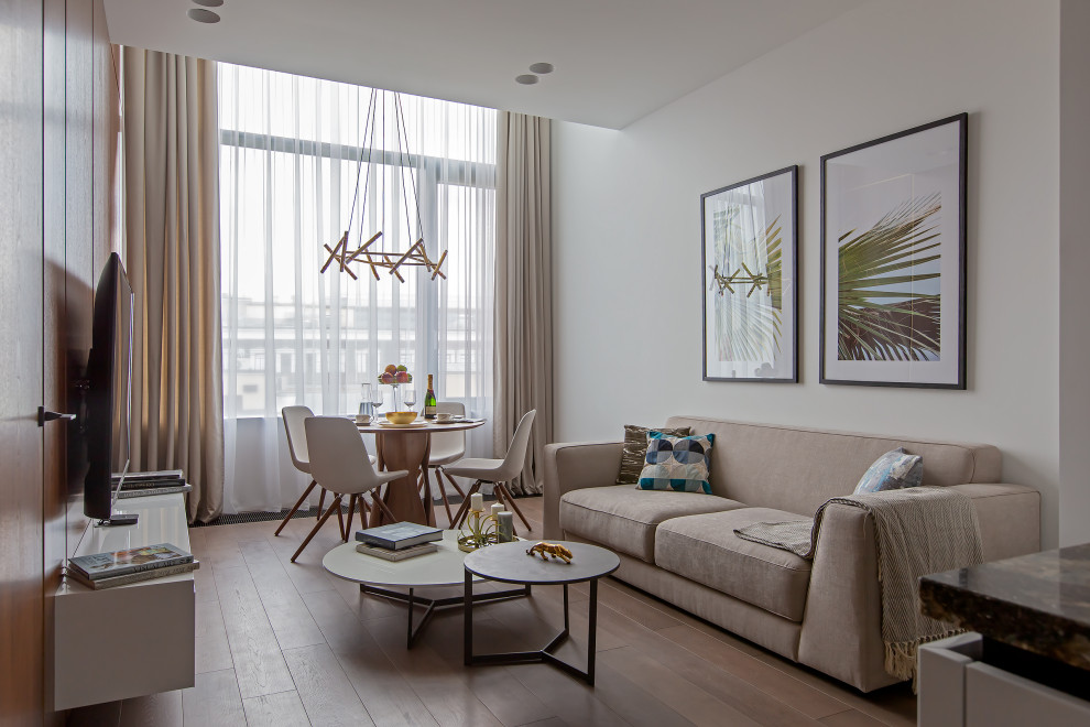 Idée de décoration pour un salon design ouvert avec un mur blanc, un sol en bois brun et un sol marron.