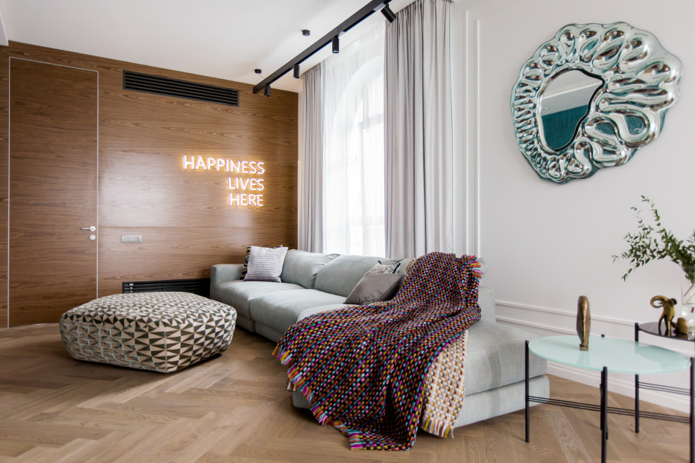 На фото: гостиная комната в современном стиле с белыми стенами, светлым паркетным полом и коричневым полом с