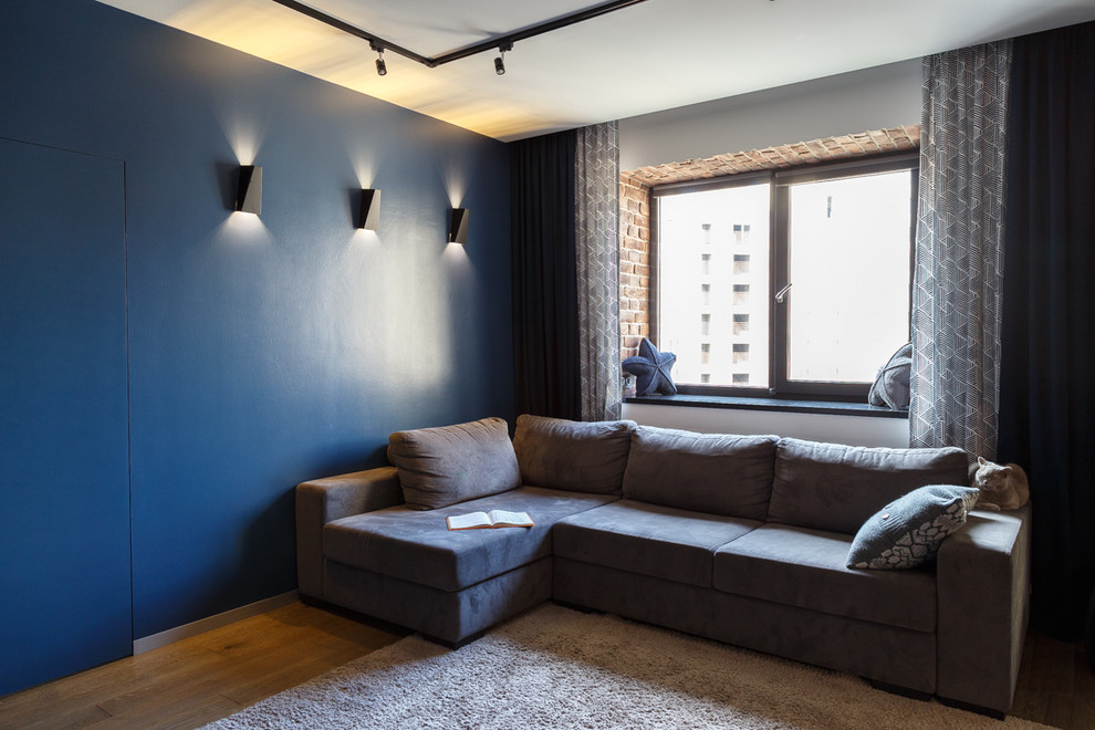 На фото: гостиная комната в современном стиле с синими стенами